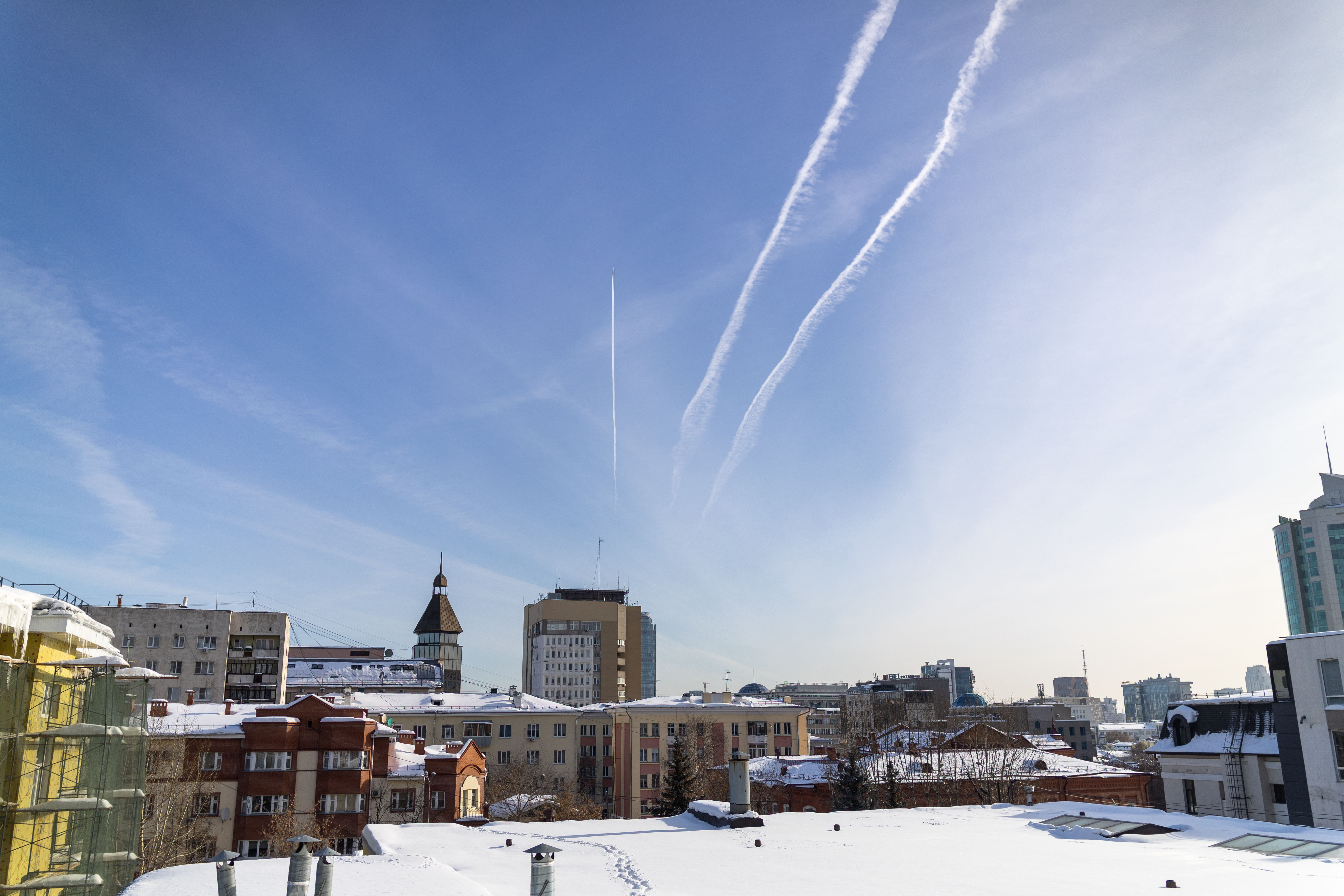Городской пруд зимой: люди идут по льду, силуэты на белом фоне — масштаб и настроение.